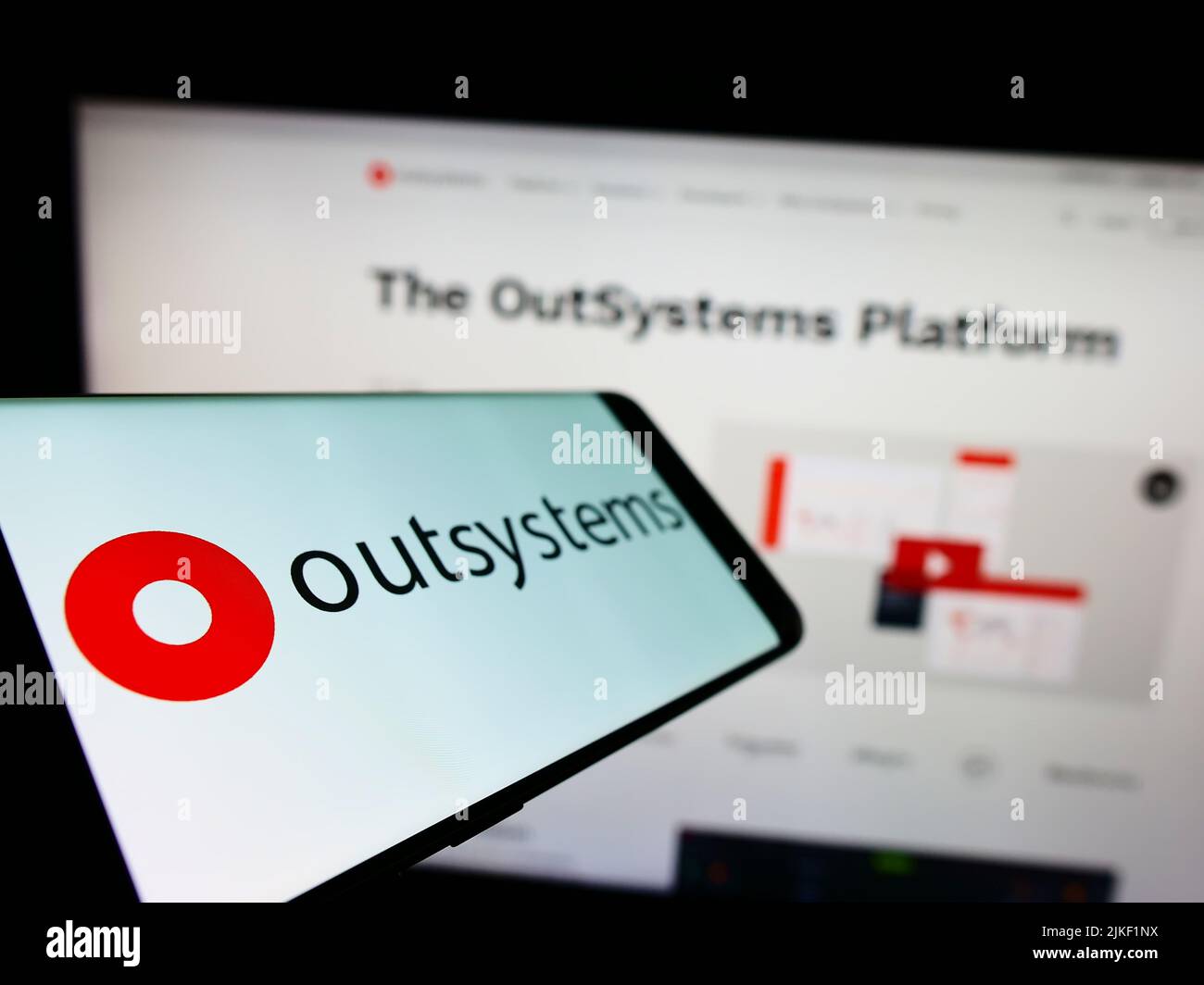 Téléphone mobile avec logo de la société de logiciel à code faible OutSystems sur l'écran devant le site Web d'affaires. Mise au point à gauche de l'écran du téléphone. Banque D'Images