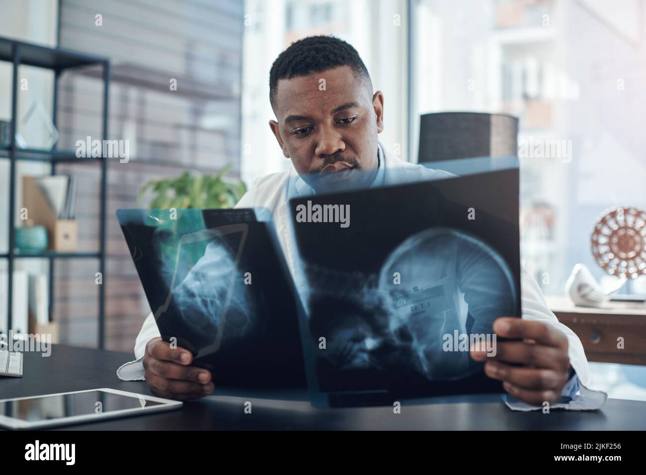 Mieux vaut prévenir que guérir : un jeune médecin examine une radiographie dans un bureau. Banque D'Images