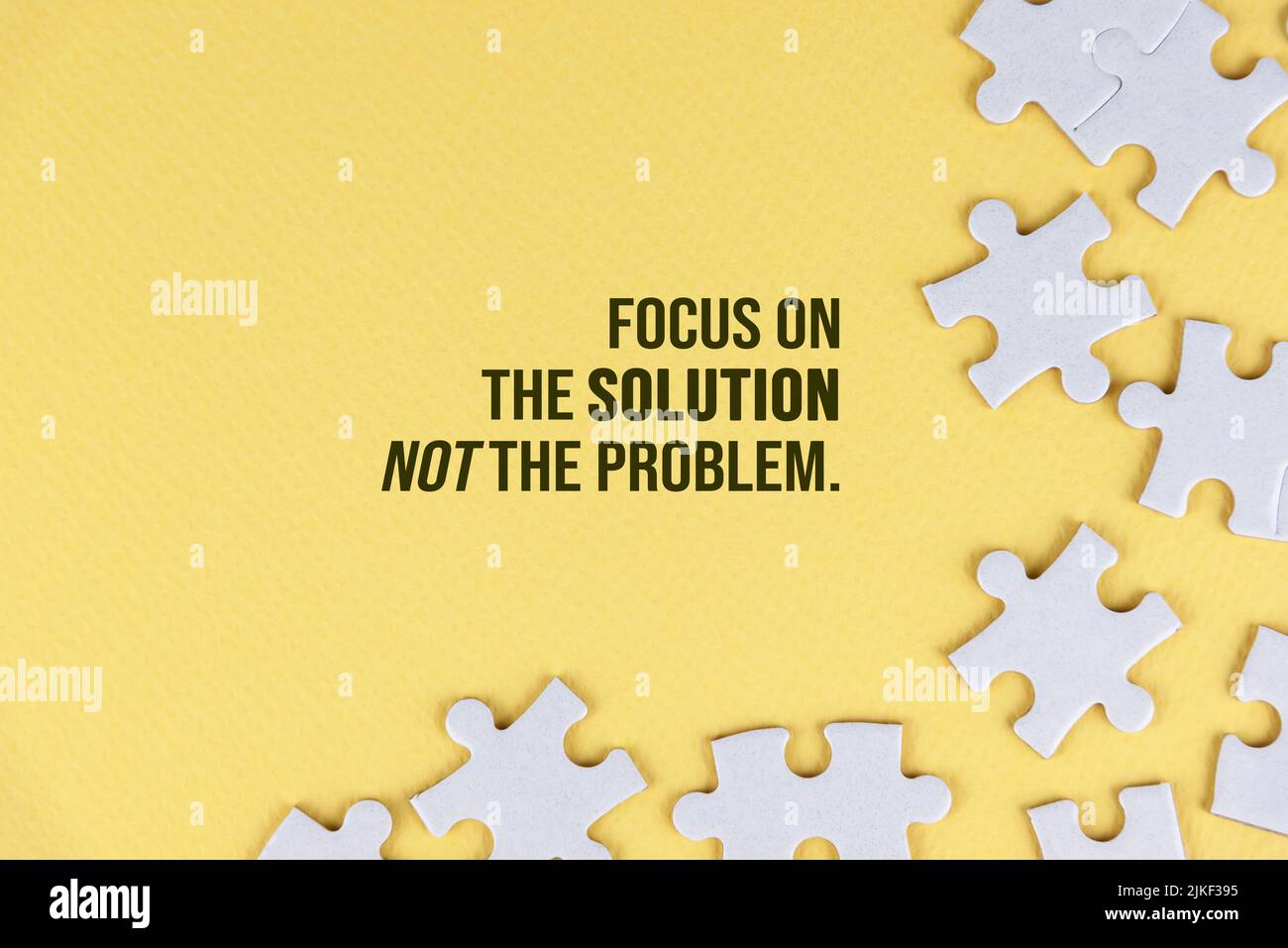 Citation motivationnelle : concentrez-vous sur la solution et non sur le problème. Avec fond de puzzle blanc sur fond jaune pâle. Solution de vie et d'entreprise. Banque D'Images