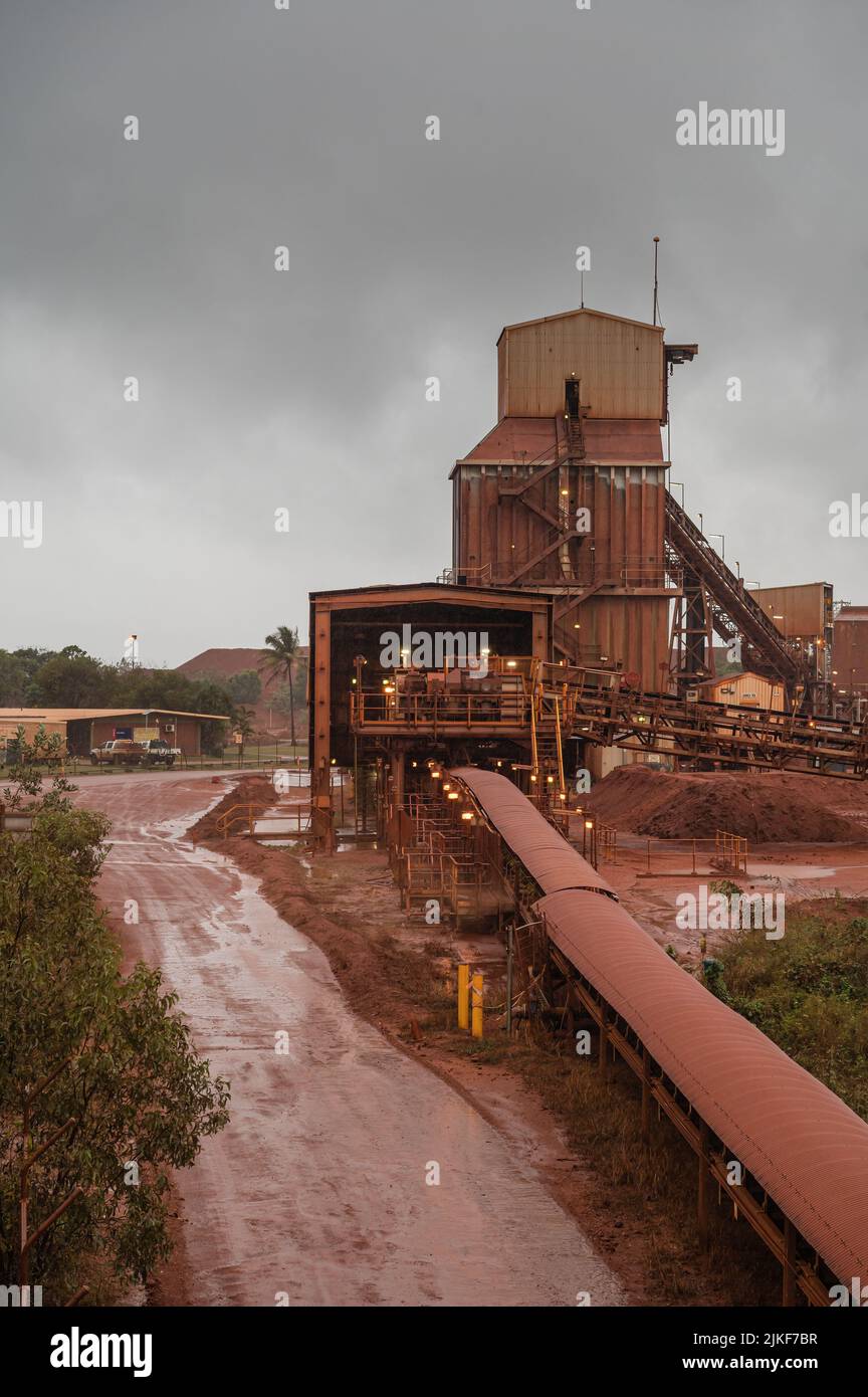 Le temps humide met en évidence la poussière rouge-orange qui recouvre la raffinerie de bauxite Nhulunbuy sur la péninsule de Gove, dans le territoire du Nord de l'Australie. Banque D'Images