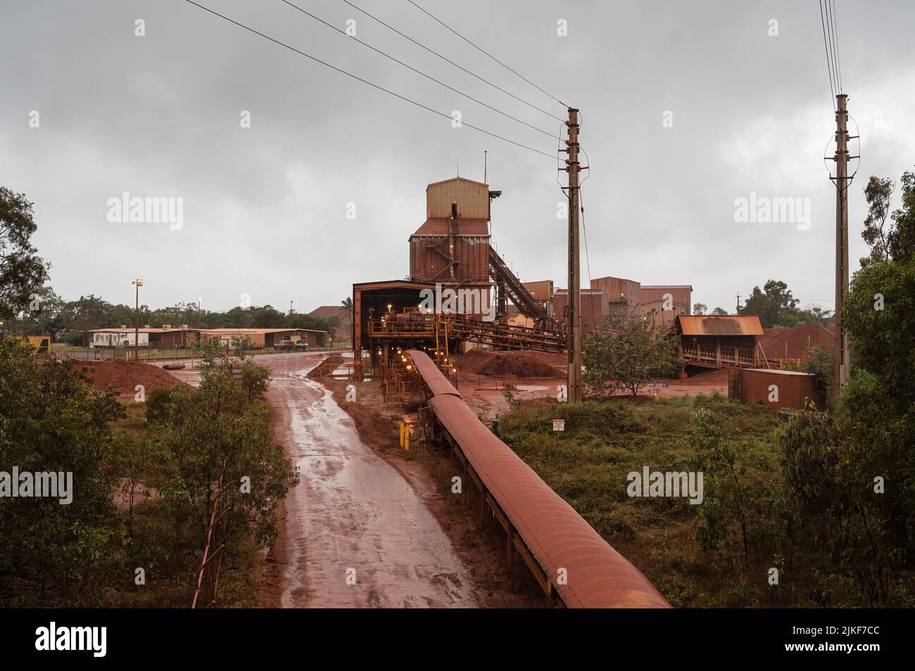 Le temps humide met en évidence la poussière rouge-orange qui recouvre la raffinerie de bauxite Nhulunbuy sur la péninsule de Gove, dans le territoire du Nord de l'Australie. Banque D'Images