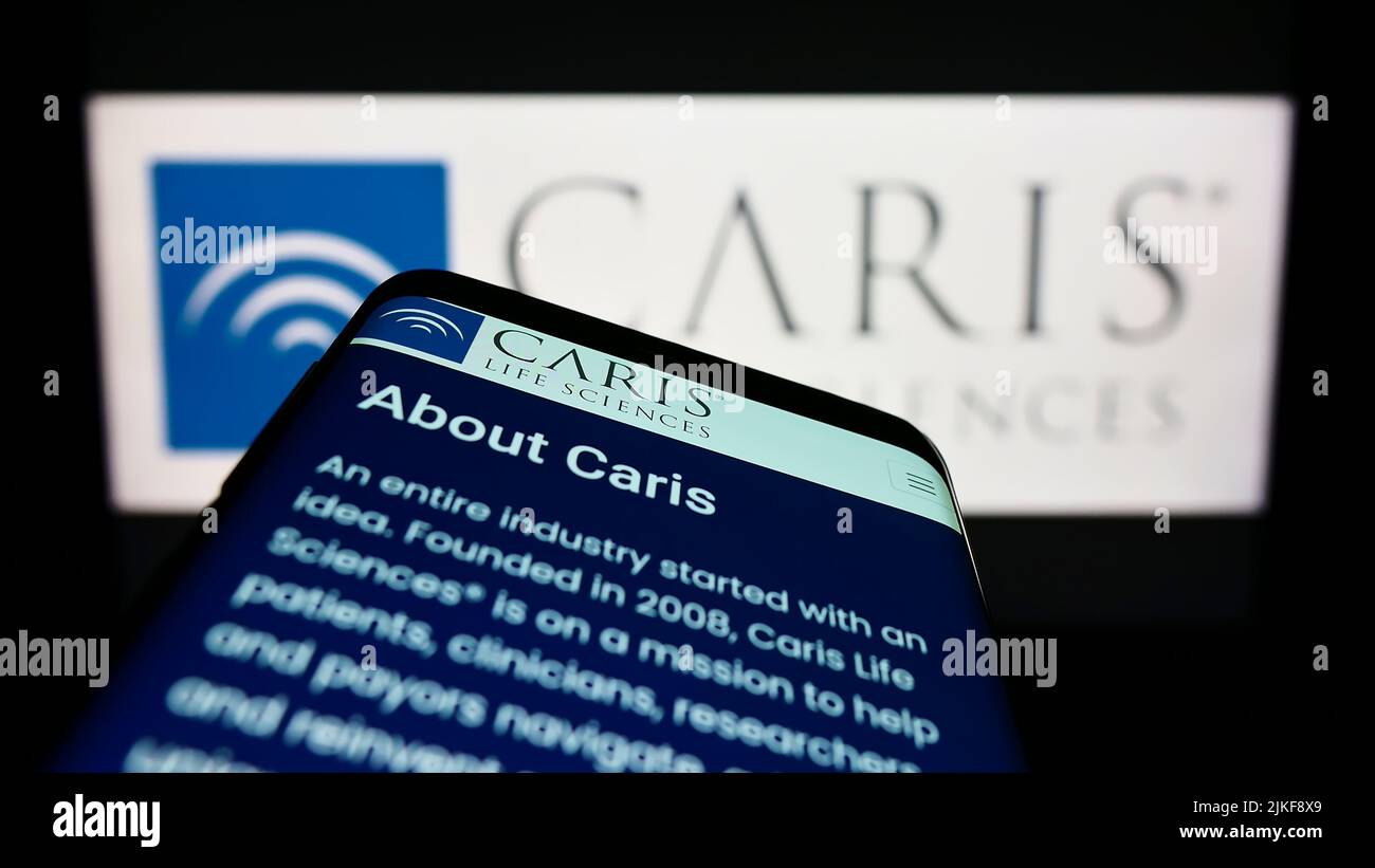 Smartphone avec la page web de la société américaine de biotechnologie CARIS Life Sciences à l'écran devant le logo de l'entreprise. Faites la mise au point dans le coin supérieur gauche de l'écran du téléphone. Banque D'Images