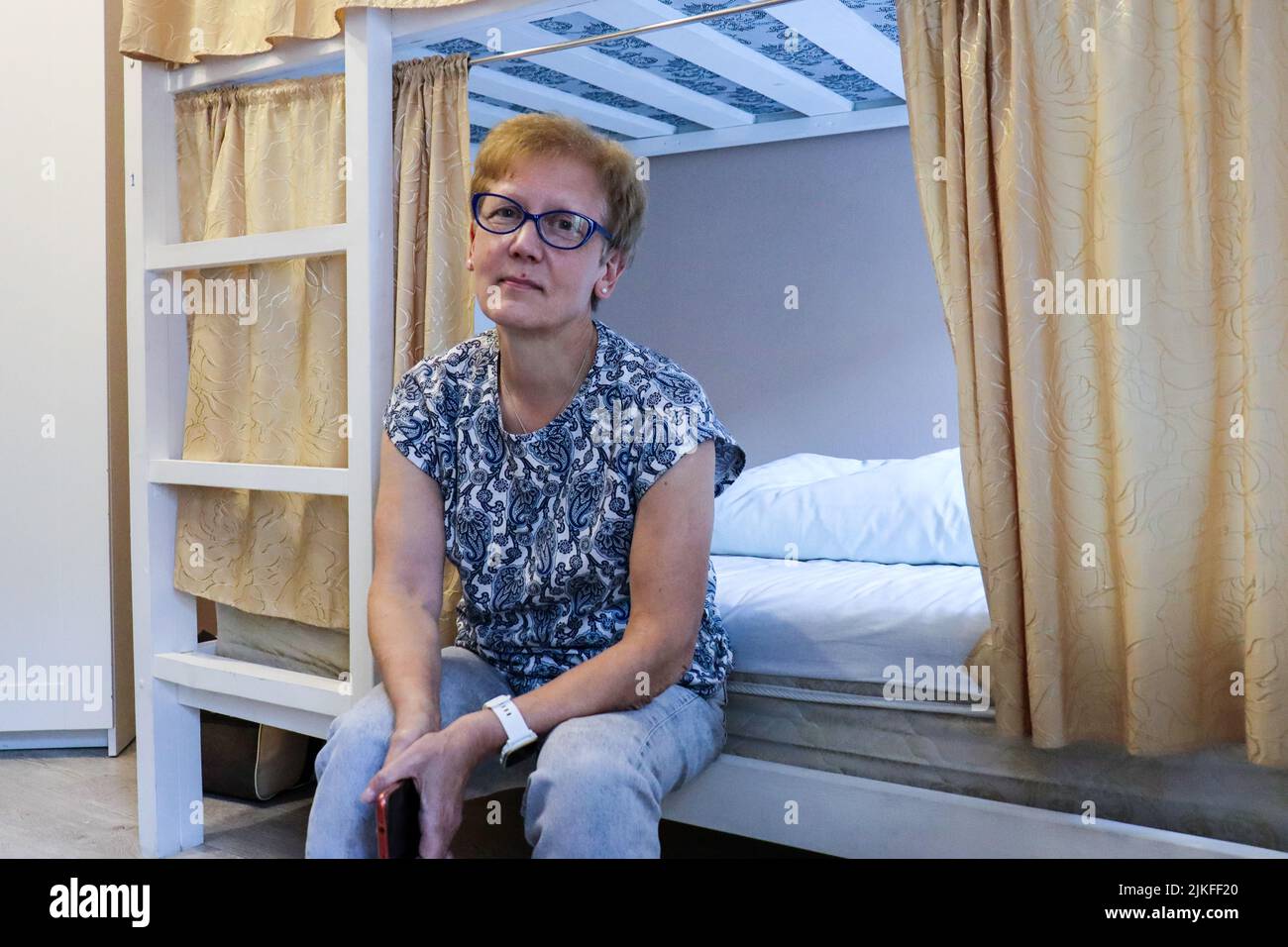 Saint-Pétersbourg, Russie. 17th juillet 2022. Russian Svetlana Kvashina se trouve sur un lit dans une auberge de Saint-Pétersbourg où elle s'occupe des réfugiés ukrainiens. Credit: Hannah Wagner/dpa/Alay Live News Banque D'Images