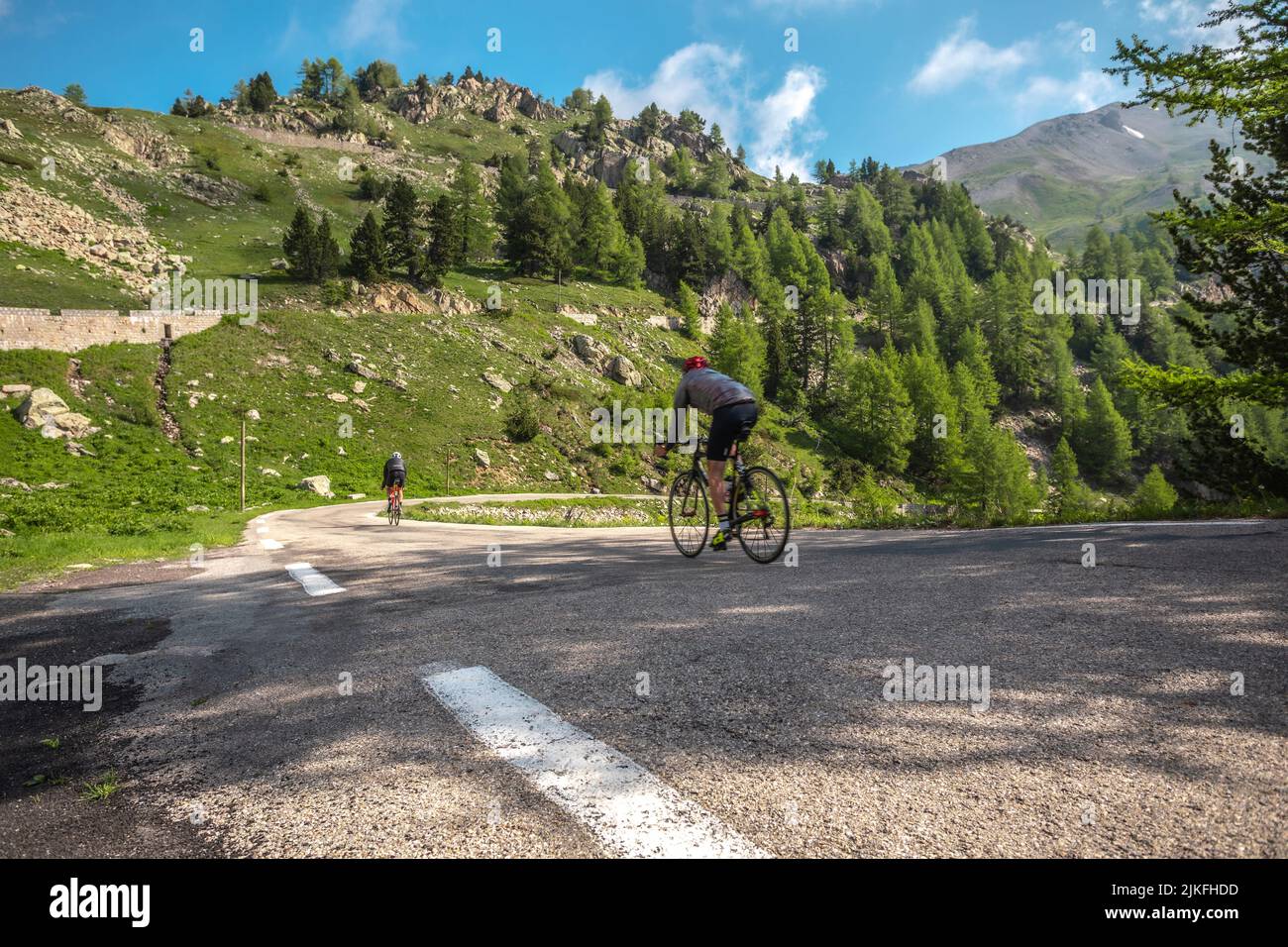 Cyclistes descendant du Col de la Cayolle dans les montagnes en France Banque D'Images