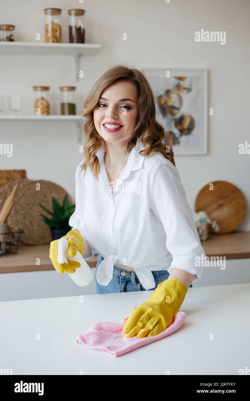 Femme de ménage en gants jaunes essuie la table de cuisine Photo Stock -  Alamy