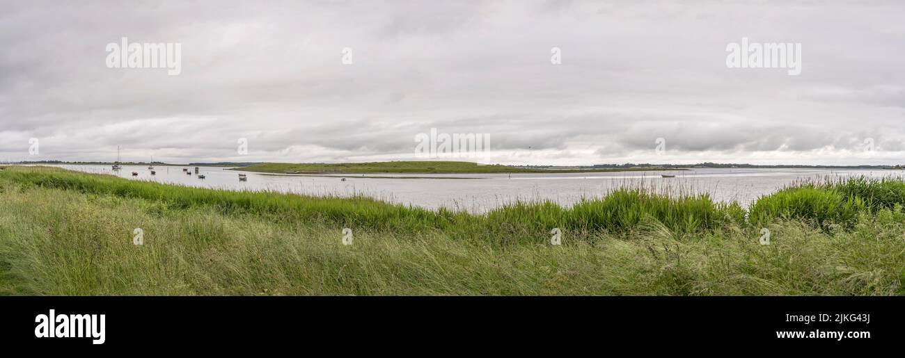 Bateaux amarrés dans le paysage du fjord avec des eaux plates et des rives vertes, filés sous une lumière claire et nuageux près de Roskilde, Sjaellands, Danemark Banque D'Images