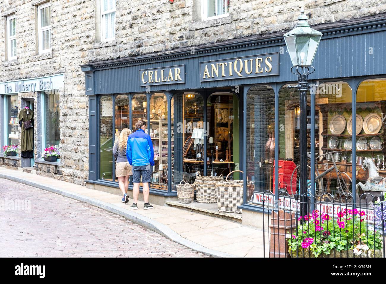 Village de Hawes dans le Yorkshire Dales, magasin d'antiquités local avec deux personnes regardant dans la fenêtre, Angleterre, Royaume-Uni, été 2022 Banque D'Images