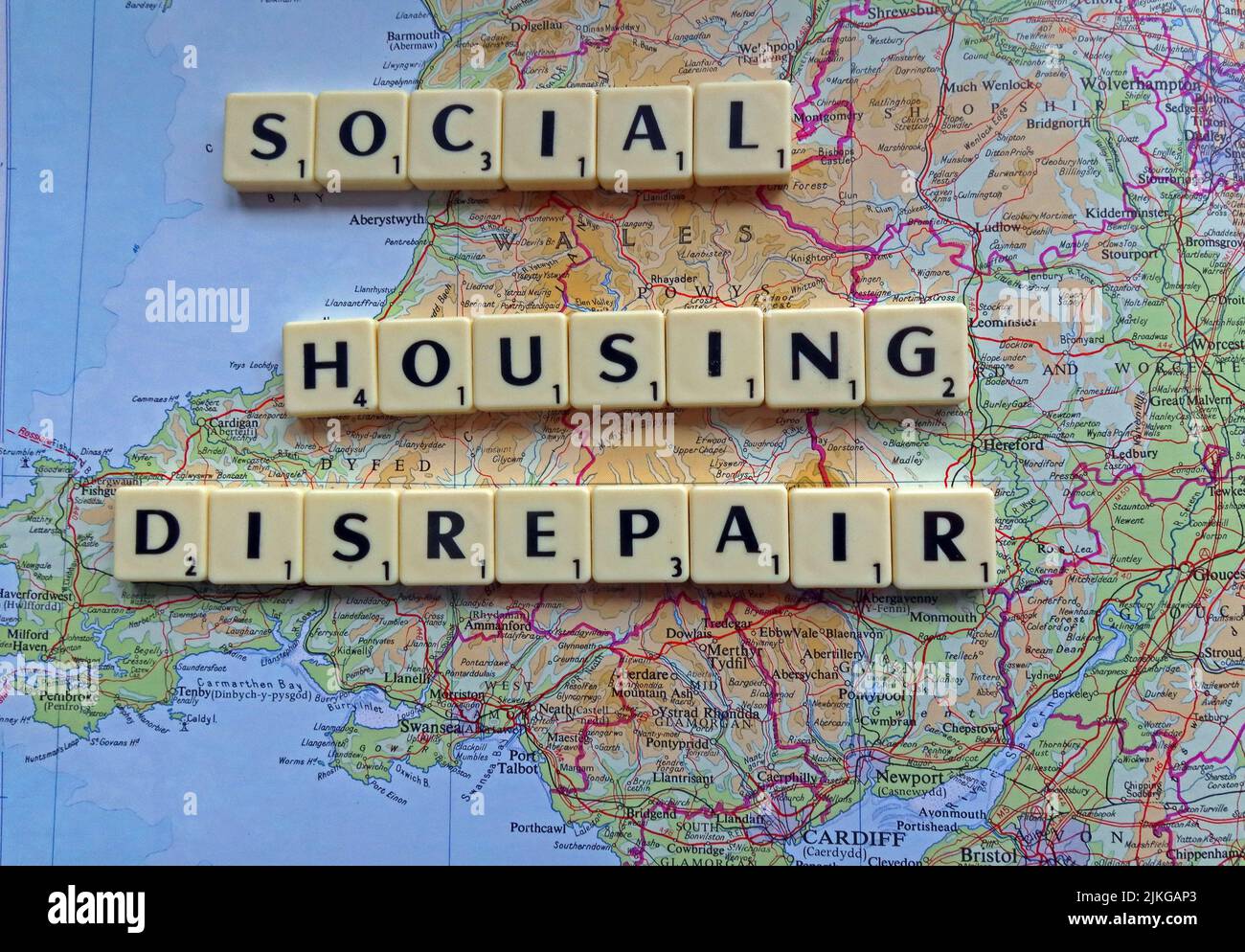 Welsh SocialHousing / Conseil des problèmes de réparation de logements avec des réparations réactives énoncées dans les lettres Scrabble sur une carte du sud du pays de Galles Banque D'Images