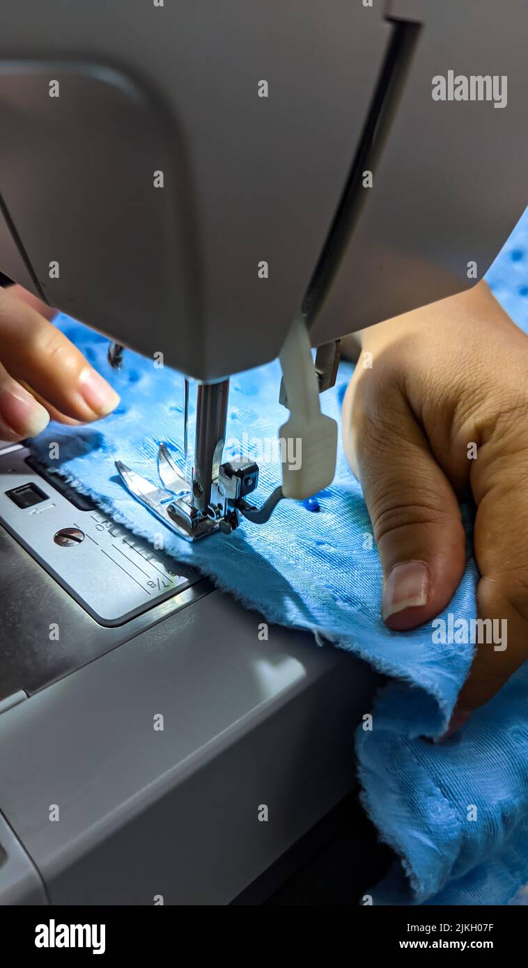 Gros plan des mains de couturière travaillant sur une machine à coudre Banque D'Images