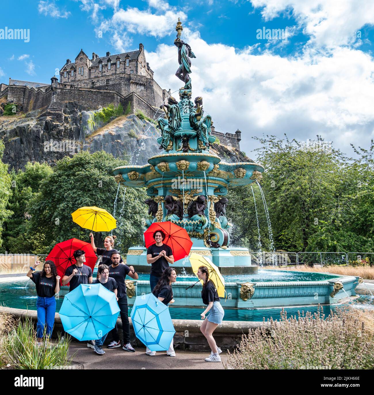 Édimbourg, Écosse, Royaume-Uni, 2nd août 2022. Edinburgh Festival Fringe: Friendsical le spectacle musical est une célébration et une parodie des célèbres amis de la série télévisée américaine. Les acteurs recréent les crédits d'ouverture de la série télé à succès dans par la fontaine Ross dans Princes Street Gardens avec des parasols colorés Banque D'Images
