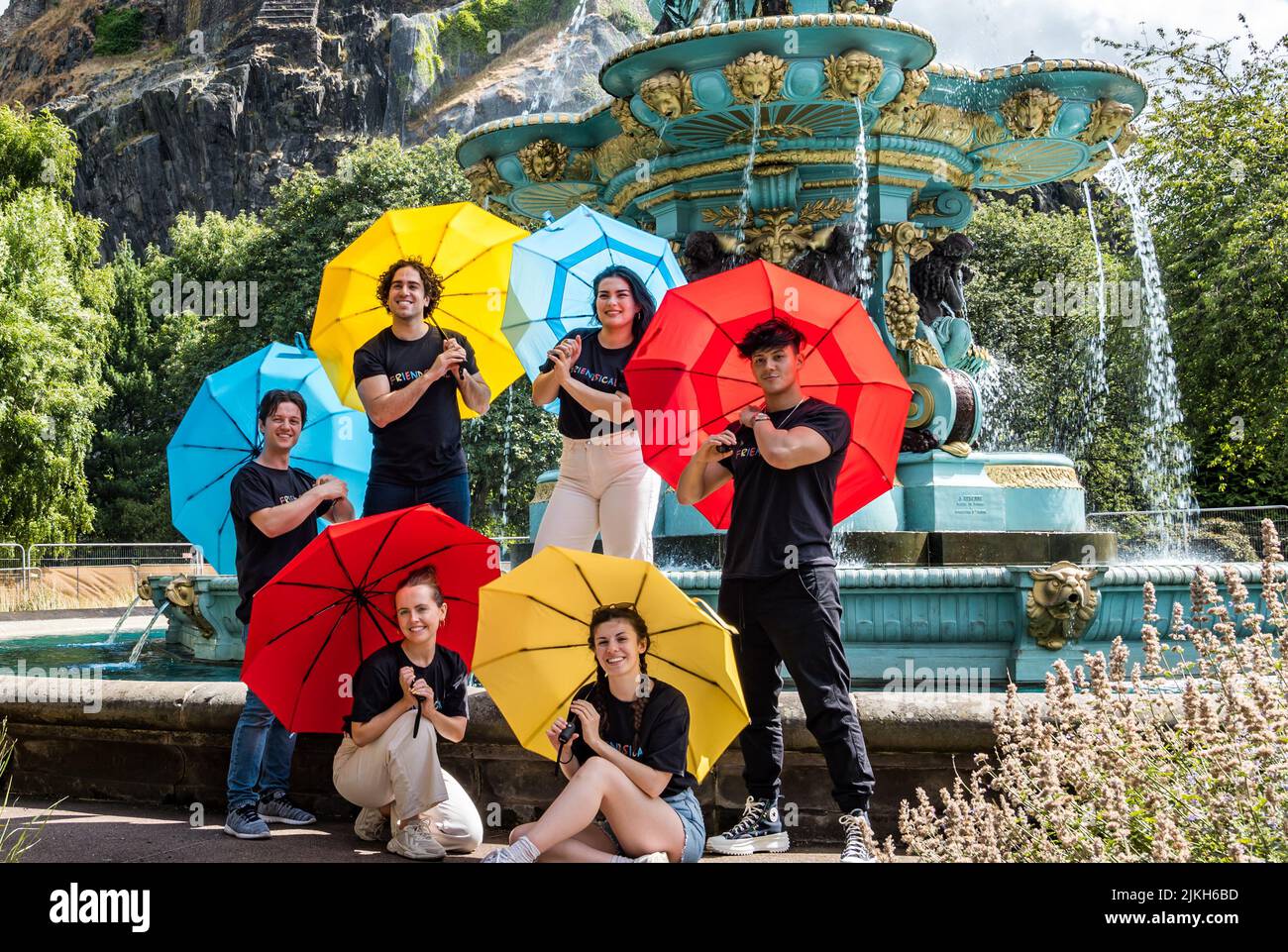 Édimbourg, Écosse, Royaume-Uni, 2nd août 2022. Edinburgh Festival Fringe: Friendsical le spectacle musical est une célébration et une parodie des célèbres amis de la série télévisée américaine. Les acteurs recréent les crédits d'ouverture de la série télé à succès dans par la fontaine Ross dans Princes Street Gardens avec des parasols colorés Banque D'Images