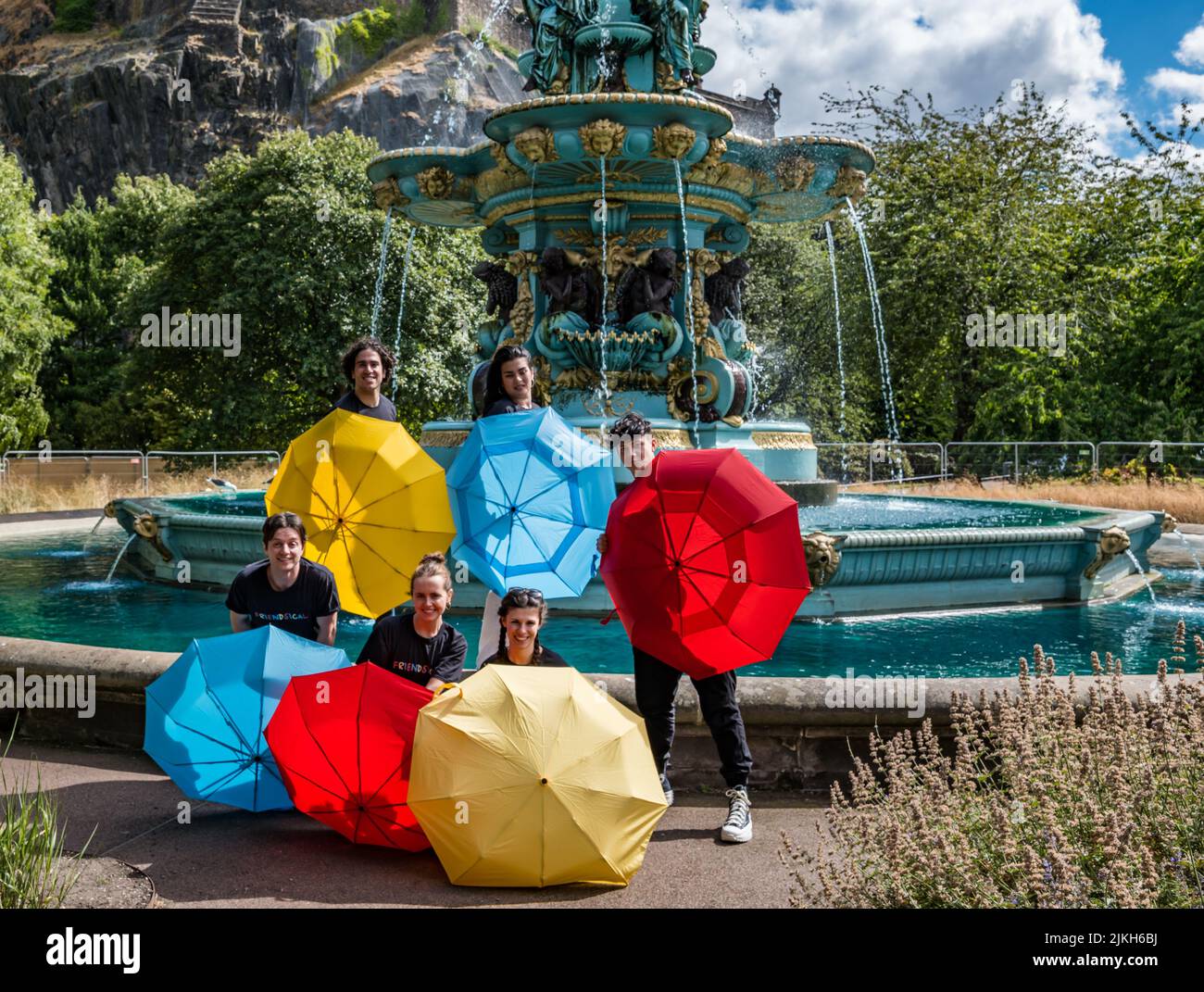 Édimbourg, Écosse, Royaume-Uni, 2nd août 2022. Edinburgh Festival Fringe: Friendsical le spectacle musical est une célébration et une parodie des célèbres amis de la série télévisée américaine. Les acteurs recréent les crédits d'ouverture de la série télé à succès dans par la fontaine Ross dans Princes Street Gardens avec des parasols colorés Banque D'Images