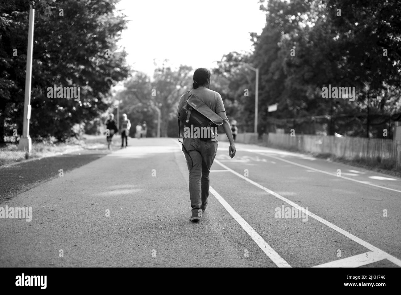 Une photo en noir et blanc d'une personne marchant sur Prospect Park, Brooklyn NY Banque D'Images