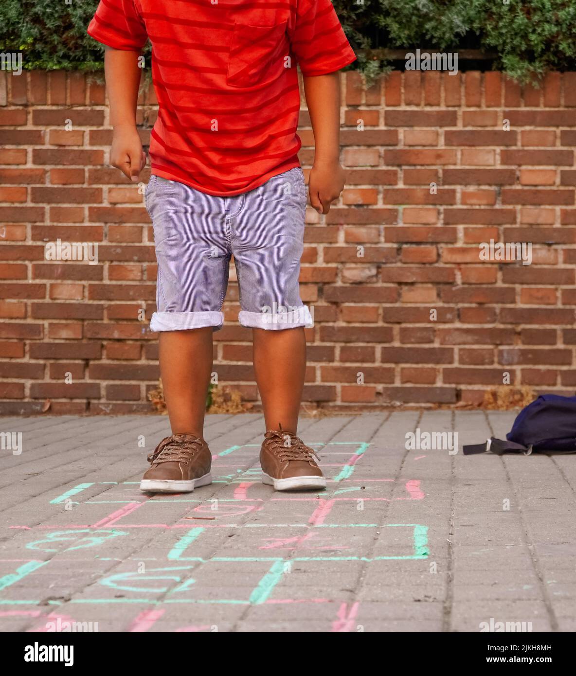 Un garçon philippin jouant du hopscotch sur le terrain de jeu de l'école. Retour au concept de l'école. Groupe multiethnique d'enfants Banque D'Images