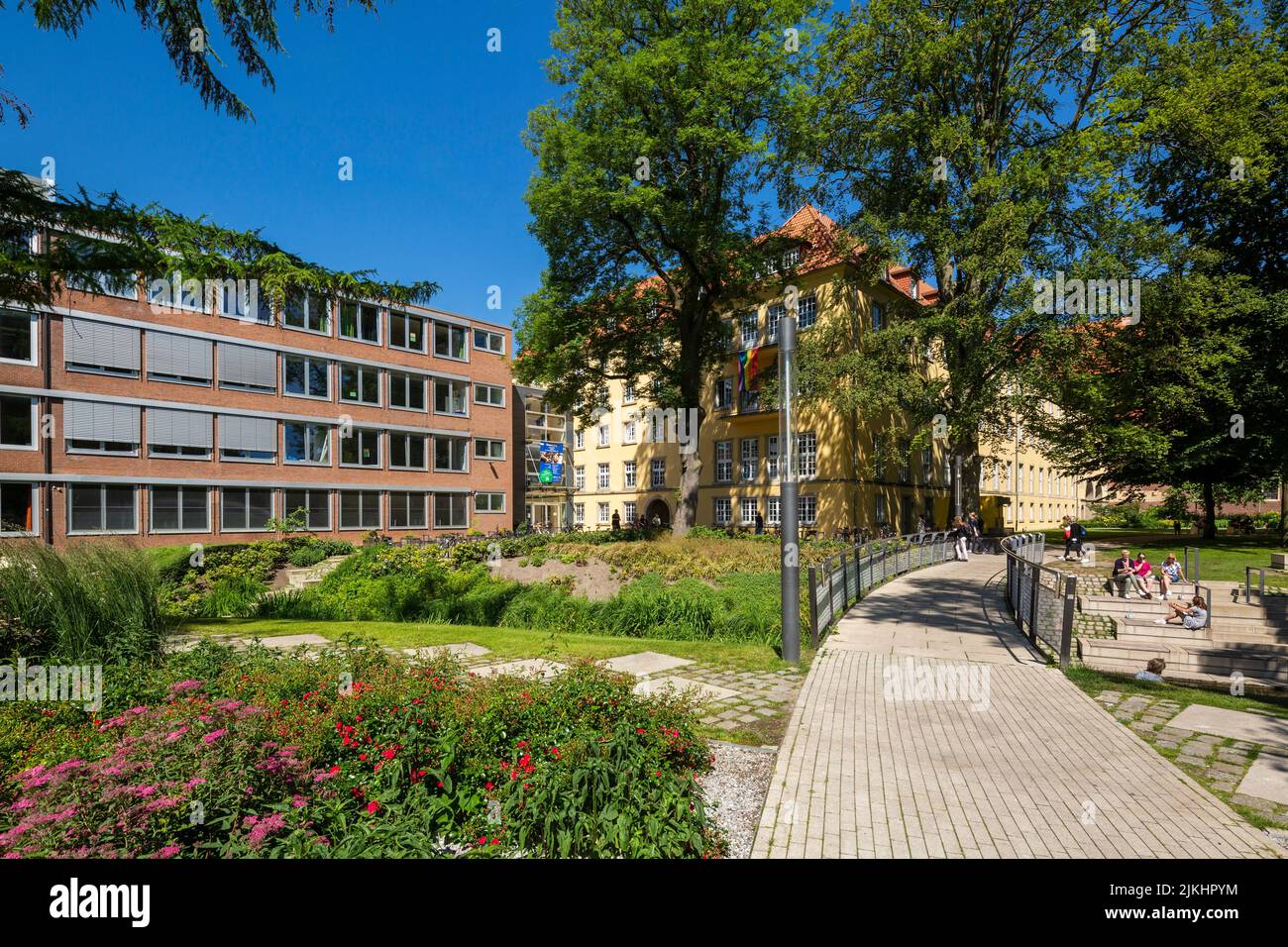 Allemagne, Coesfeld, Berkel, Baumberge, Muensterland, Westphalie, Rhénanie-du-Nord-Westphalie, Schlosspark Coesfeld, Liebfrauenschule gauche et ancien château de la ville de Coesfeld également appelé Liebfrauenburg derrière, zone verte, frontière florale, voie de transport, pont Berkel, personnes Banque D'Images