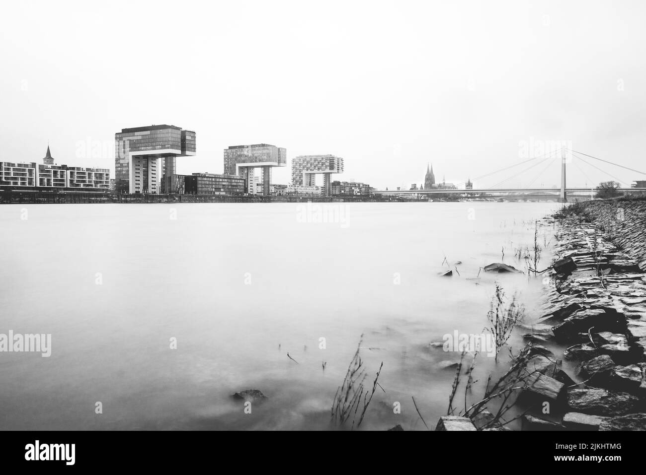 Photo en niveaux de gris d'un lac calme contre le ciel clair capturé de la côte Banque D'Images