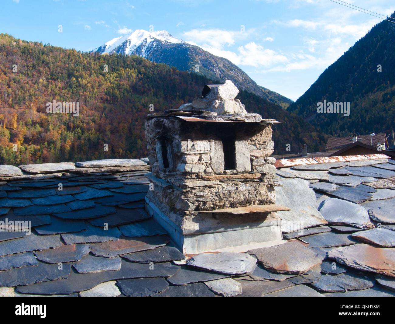 Un vieux toit de bâtiment avec des montagnes en arrière-plan Banque D'Images