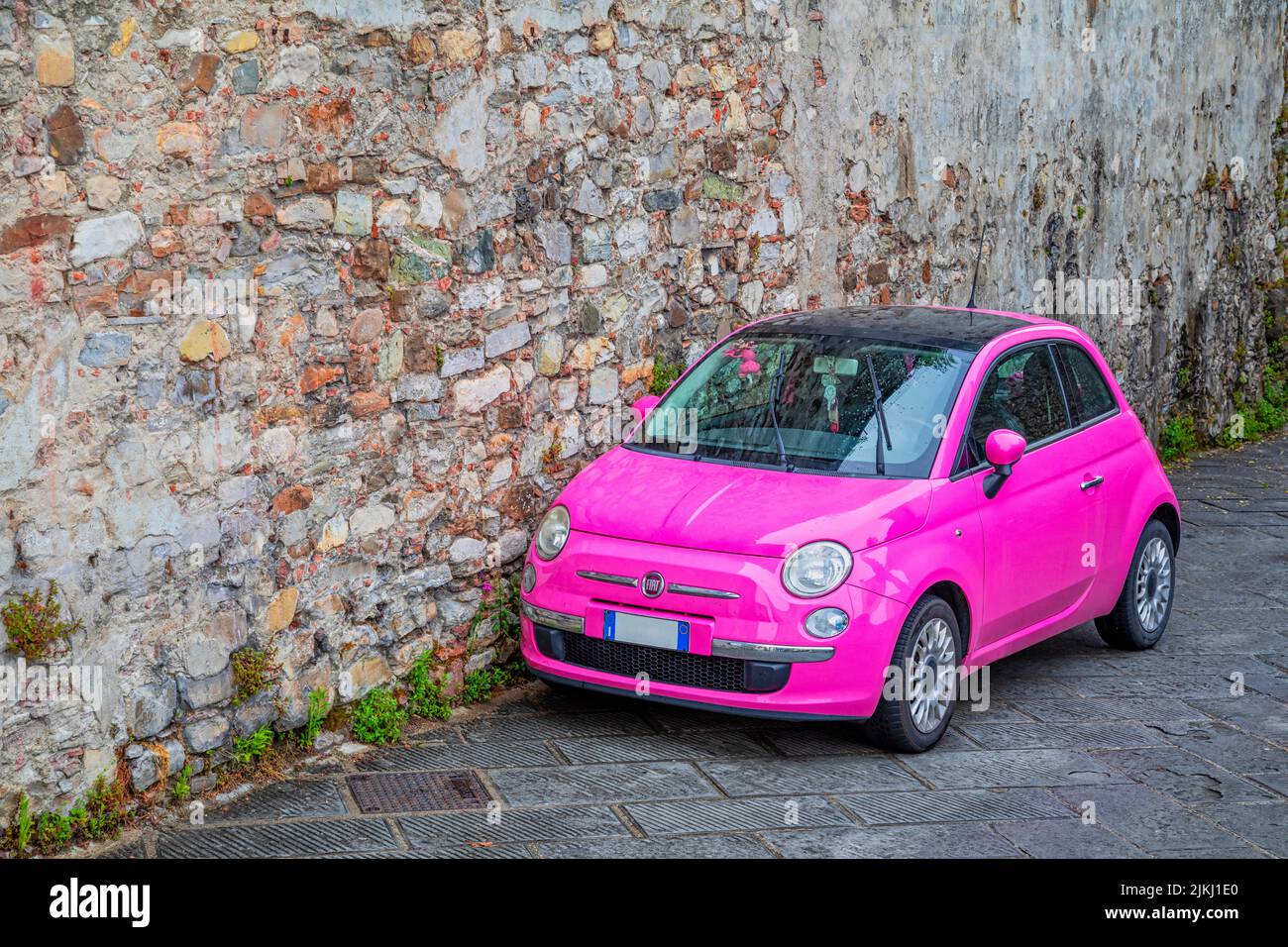 Italie, Toscane, Sienne. Une voiture de couleur rose, fiat 500, de style italien Banque D'Images