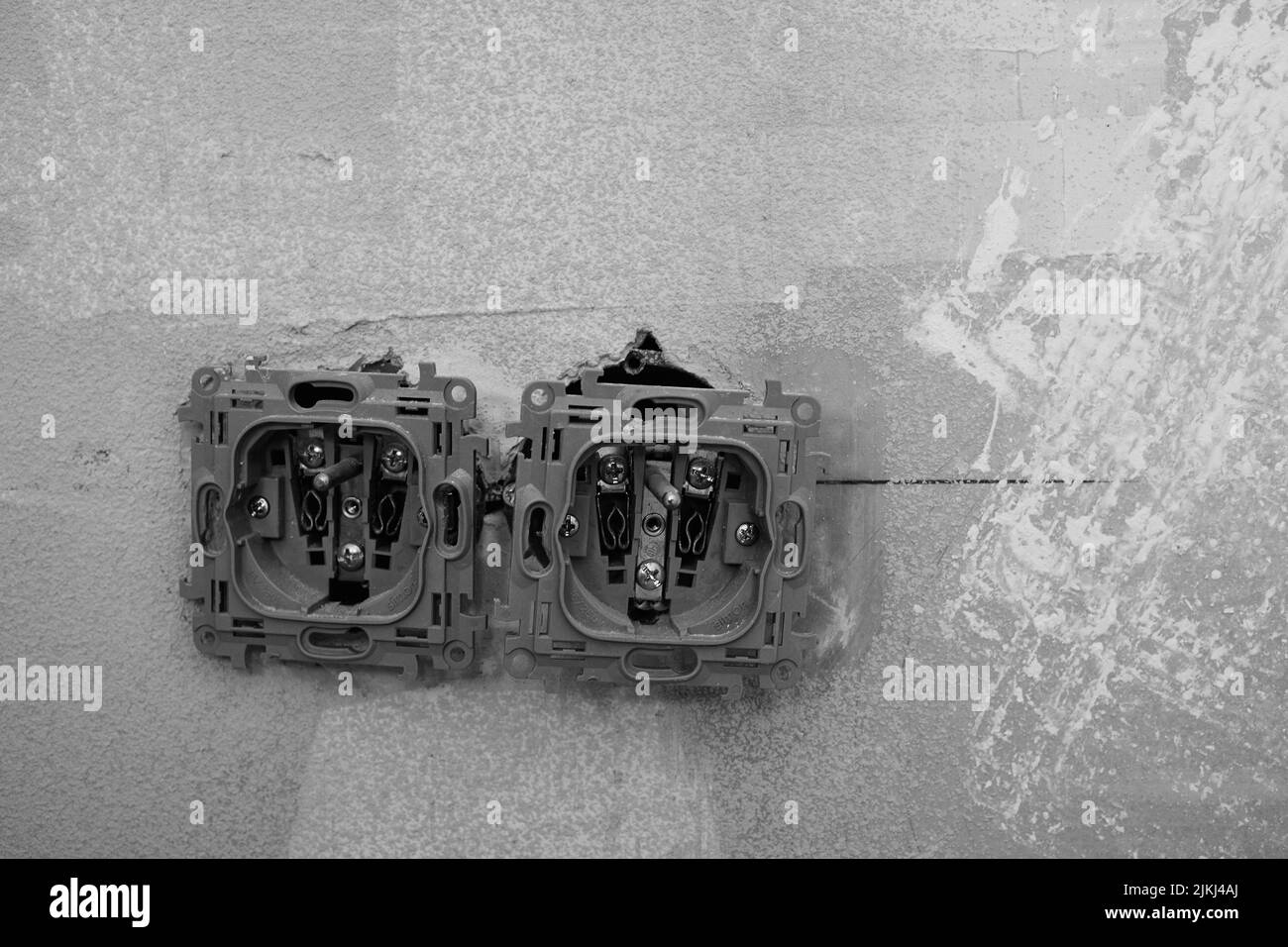 an Uncovered power sockets not isolated on a wall. Banque D'Images