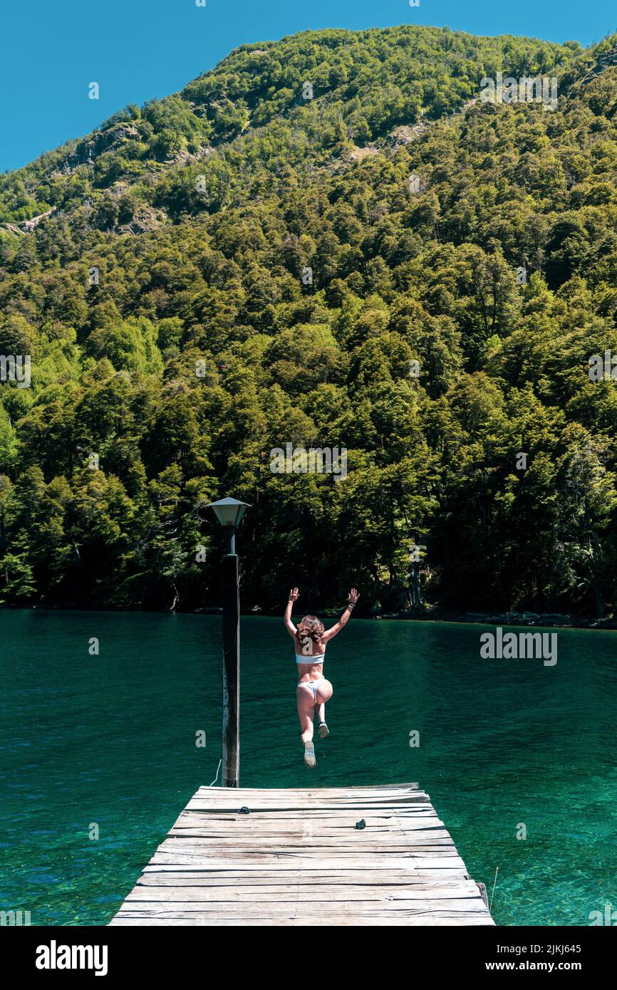 Une photo verticale d'une jeune femme qui saute dans la rivière Banque D'Images