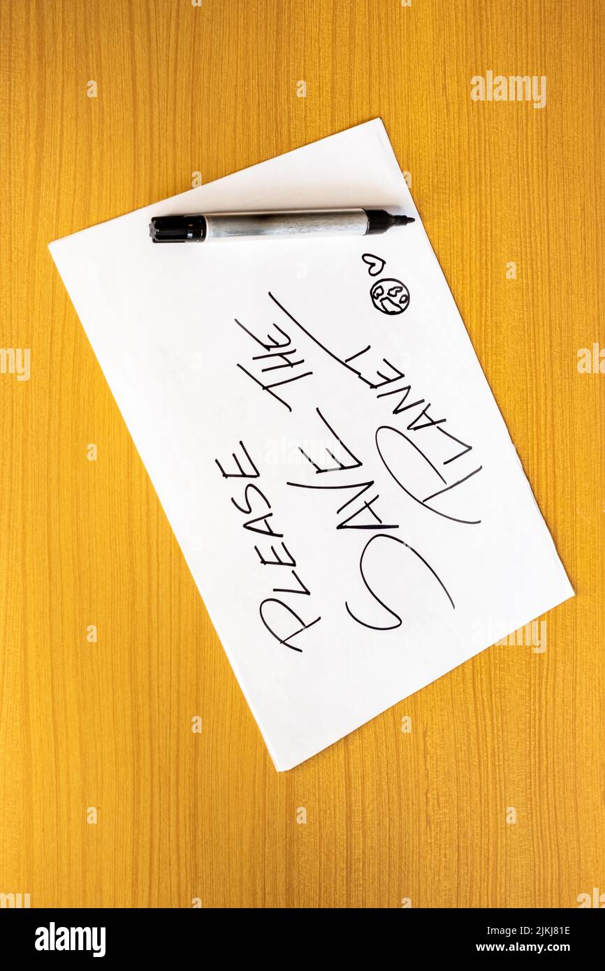 Illustration d'une feuille de papier écrite avec le message Enregistrer la planète et un marqueur à côté. Journée de la Terre, sensibilisation et protection de l'environnement o Banque D'Images