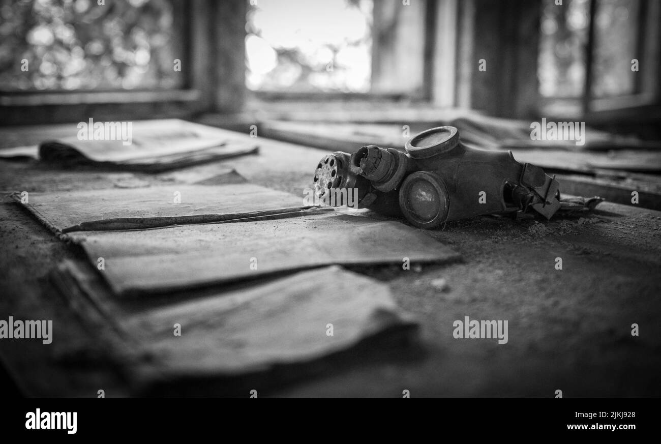 Cliché en échelle de gris d'un masque de gaz respiratoire dans un bâtiment abandonné Banque D'Images