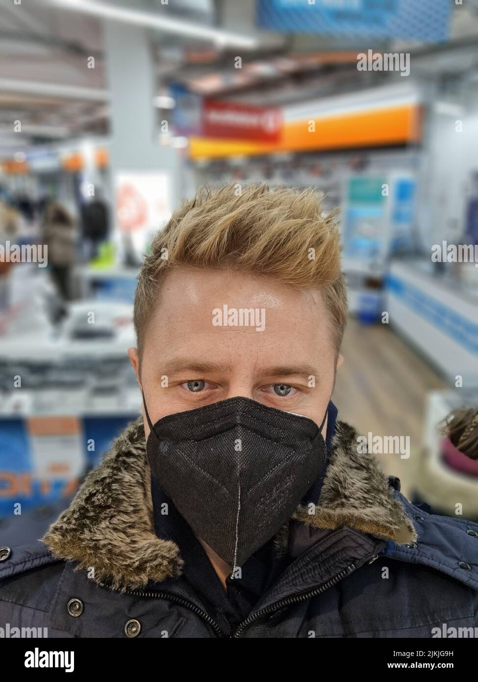 Un jeune homme avec un masque de protection dans un centre commercial Banque D'Images