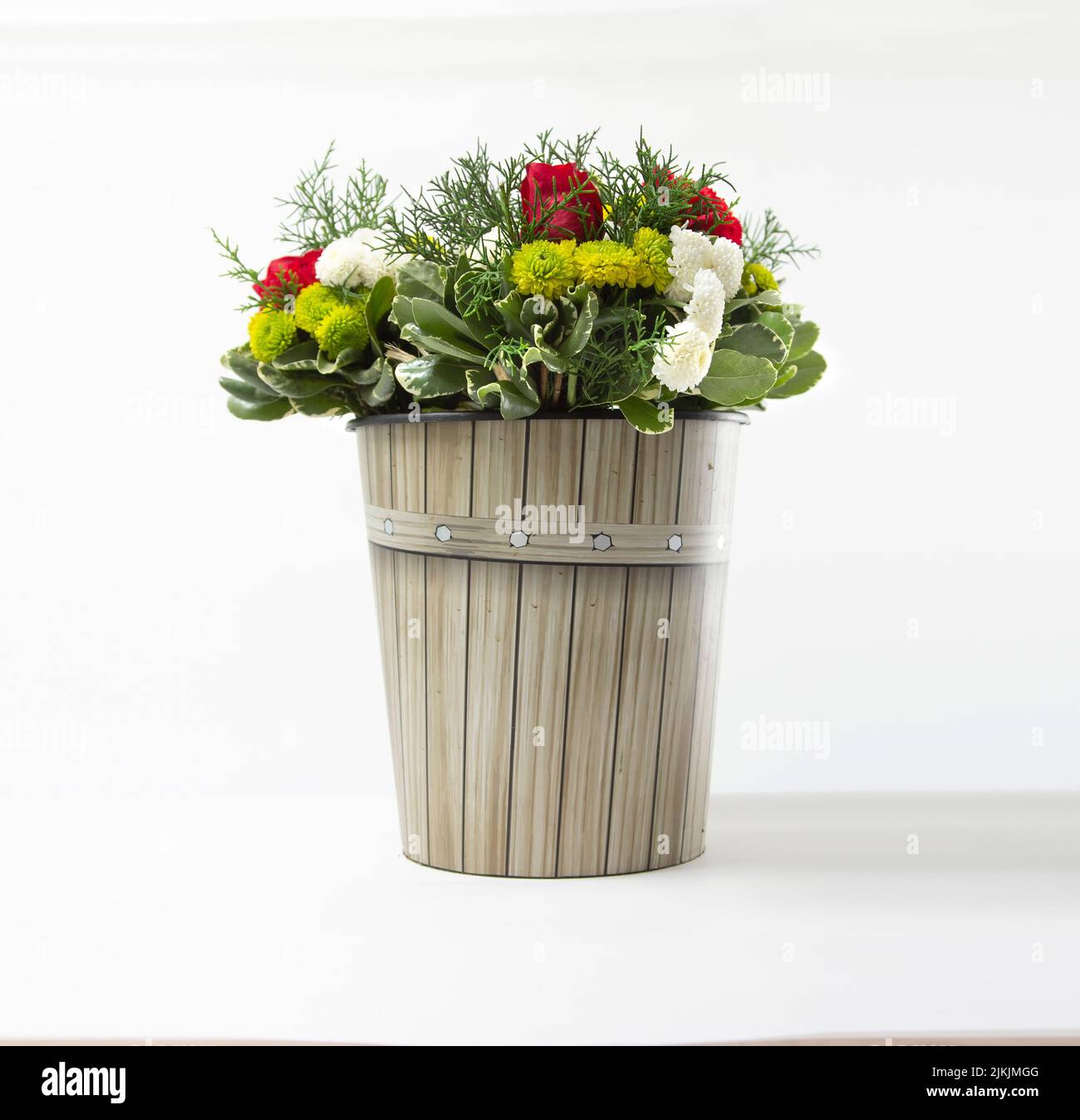 A bouquet of beautiful flowers in a white flower pot on a white background. Banque D'Images