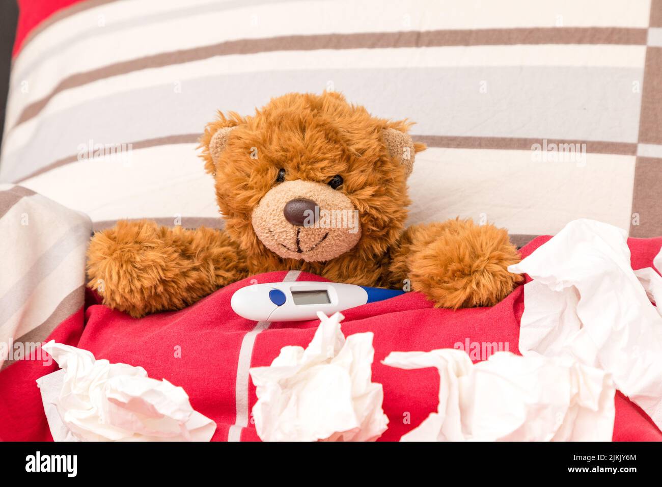 un petit ours doux est malade dans un lit Banque D'Images