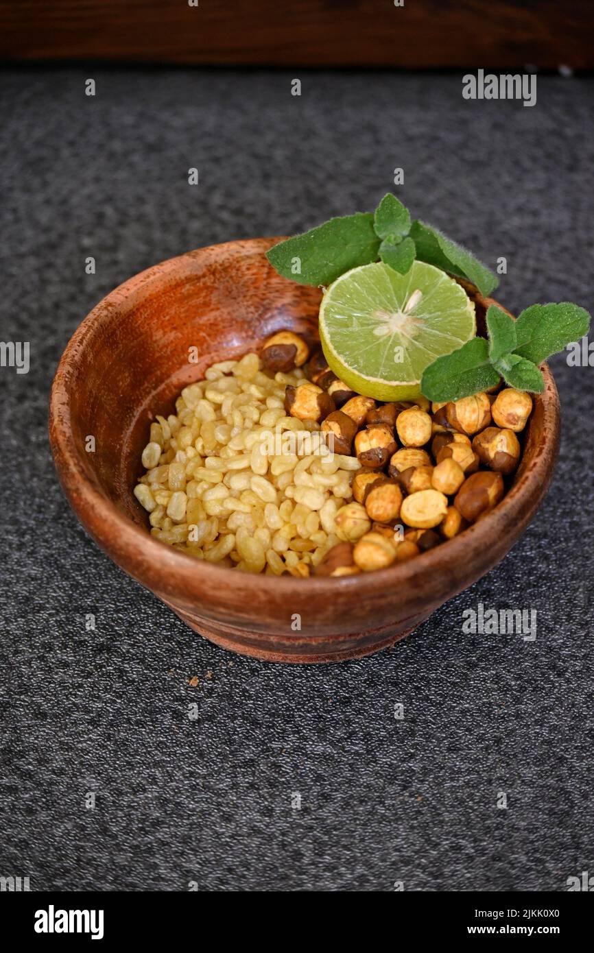 fermer les lentilles frit de gramme jaune avec du gramme noir et des tranches de citron, menthe dans le bol en bois rouge sur fond gris hors foyer. Banque D'Images