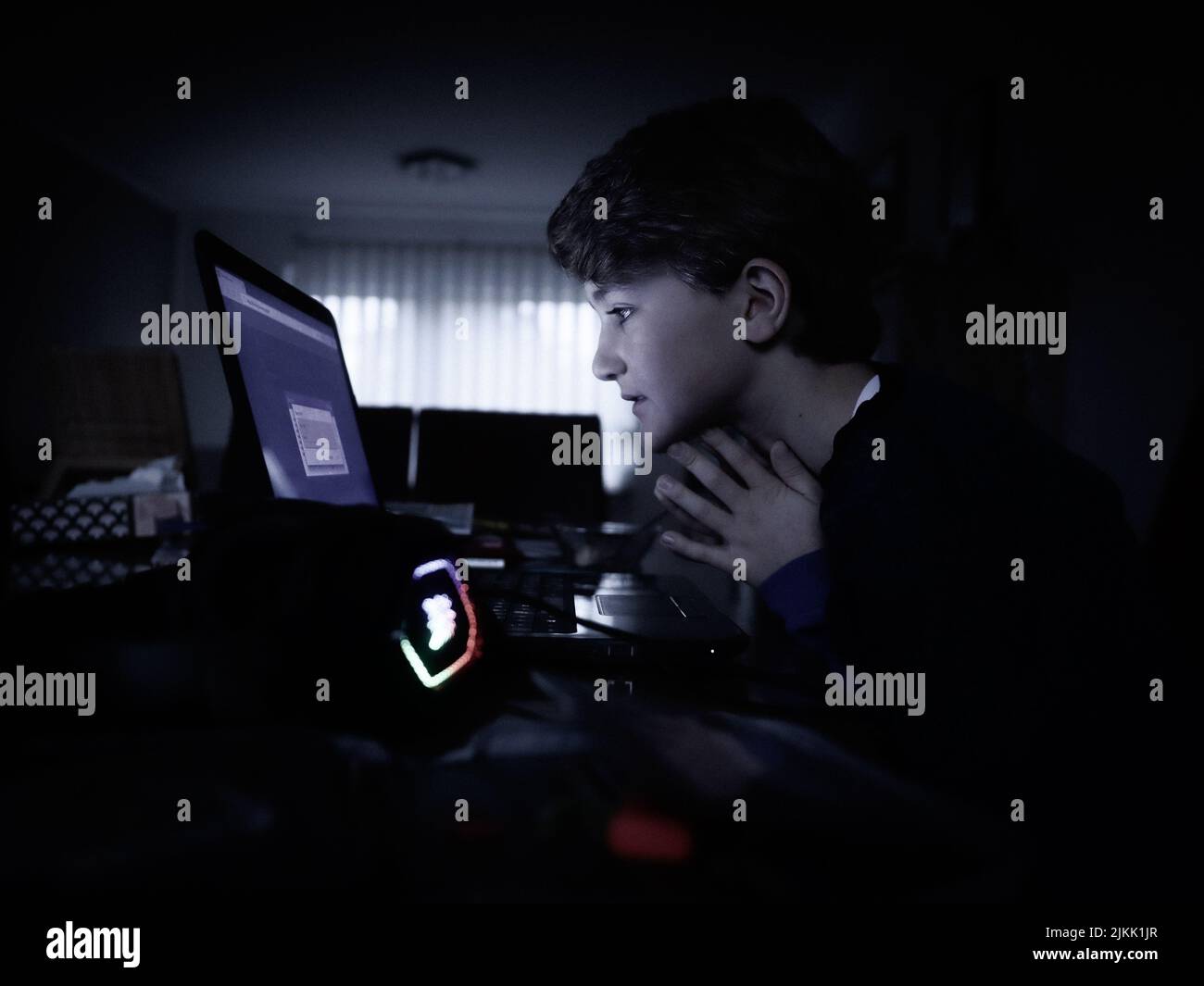 Un gros plan d'un garçon caucasien face à un ordinateur sur une table Banque D'Images