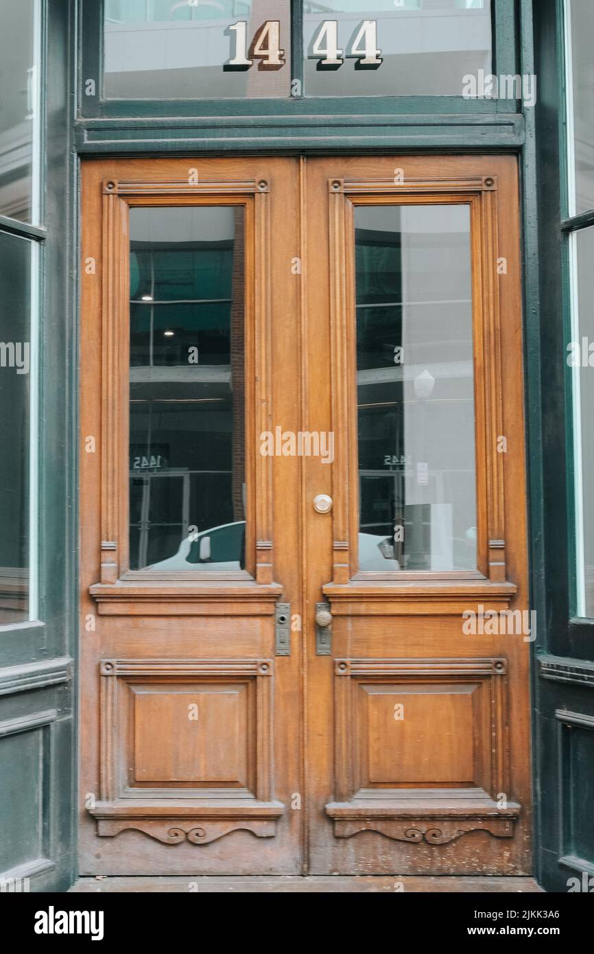 Une porte avant en bois numéro 1444 avec un reflet sur un verre Banque D'Images