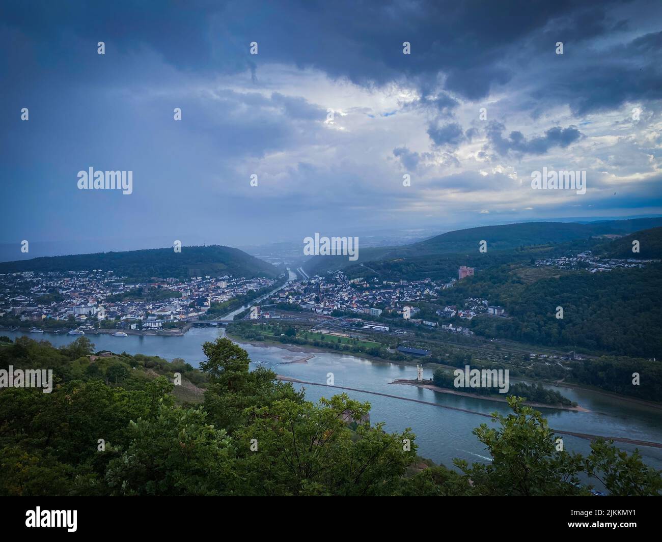 Une vue panoramique sur une rivière qui traverse la ville de Bingen am Rhein par un jour sombre en Allemagne Banque D'Images