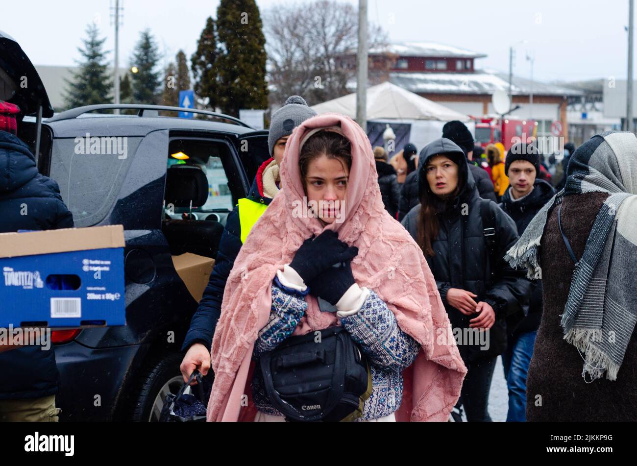Une jeune fille triste de réfugié ukrainien vient de traverser la frontière couverte de couverture à la frontière de Siret, Roumanie Banque D'Images