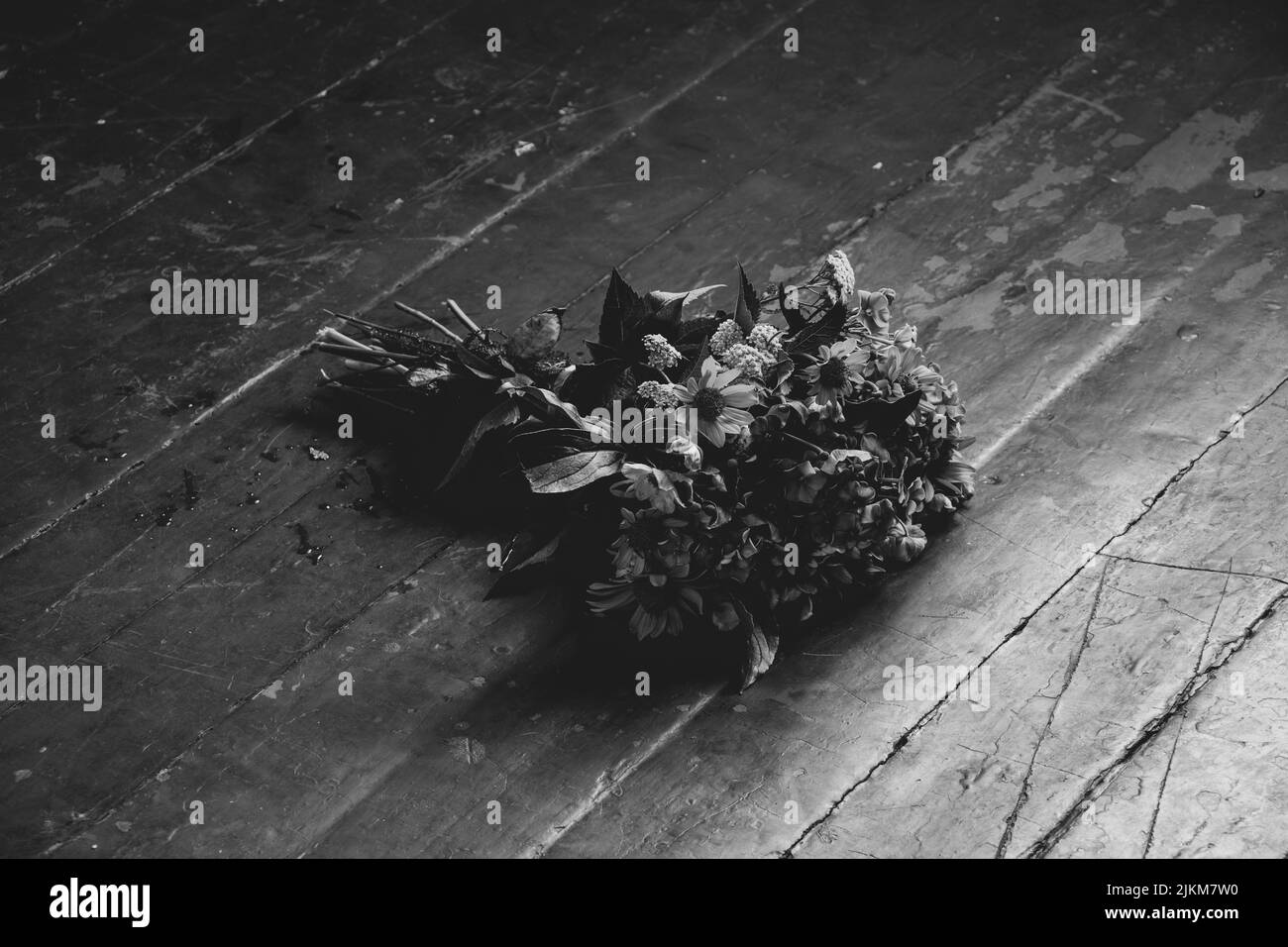 Un bouquet de fleurs sauvages se trouve sur le sol de la maison photo noir et blanc, fleurs sur le sol Banque D'Images