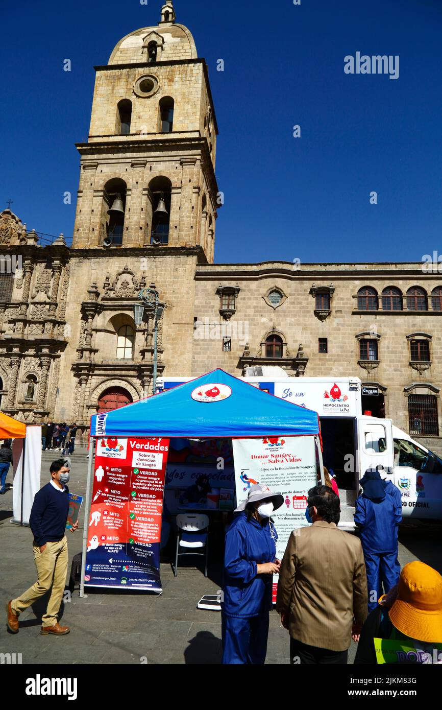 Plaza San Francisco, la Paz, Bolivie. 2nd août 2022. Un médecin parle à un membre du public à côté du centre de collecte mobile où les gens peuvent donner du sang, un service organisé par les autorités sanitaires de la Paz. Les banques de sang boliviennes comptent beaucoup sur les dons de bénévoles et de centres de collecte comme celui-ci sont courants dans la ville, en particulier pendant les périodes de vacances ou lorsqu'il y a des pénuries. Derrière se trouve l'église de San Francisco, l'église coloniale la plus importante et la plus impressionnante de la ville. Banque D'Images Plaza San Francisco, la Paz, Bolivie. 2nd août 2022. Un médecin parle à un membre du public à côté du centre de collecte mobile où les gens peuvent donner du sang, un service organisé par les autorités sanitaires de la Paz. Les banques de sang boliviennes comptent beaucoup sur les dons de bénévoles et de centres de collecte comme celui-ci sont courants dans la ville, en particulier pendant les périodes de vacances ou lorsqu'il y a des pénuries. Derrière se trouve l'église de San Francisco, l'église coloniale la plus importante et la plus impressionnante de la ville. Banque D'Images
