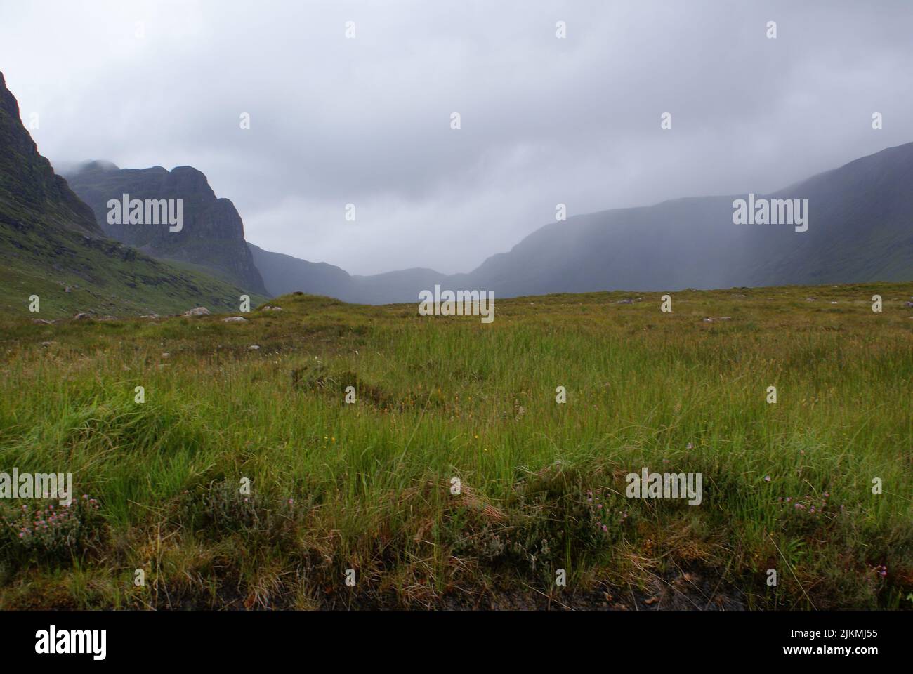 Une vue panoramique sur un terrain herbacé sous un ciel sombre en Écosse Banque D'Images