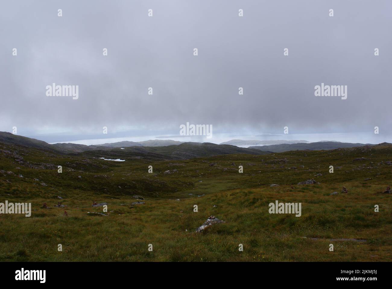 Une vue panoramique sur un terrain herbacé sous un ciel sombre en Écosse Banque D'Images