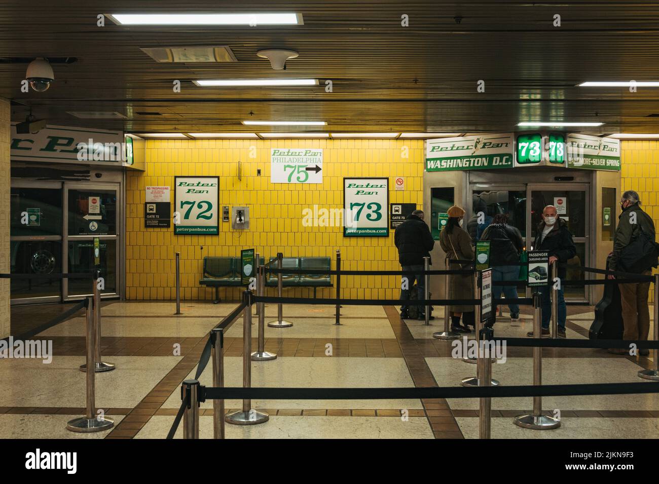 Passagers faisant la queue pour monter à bord des bus interurbains Peter Pan à Penn Station, New York Banque D'Images