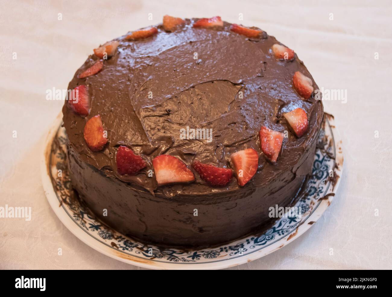 Un gâteau au chocolat aux fraises se met sur une table prête pour une fête d'anniversaire. Banque D'Images