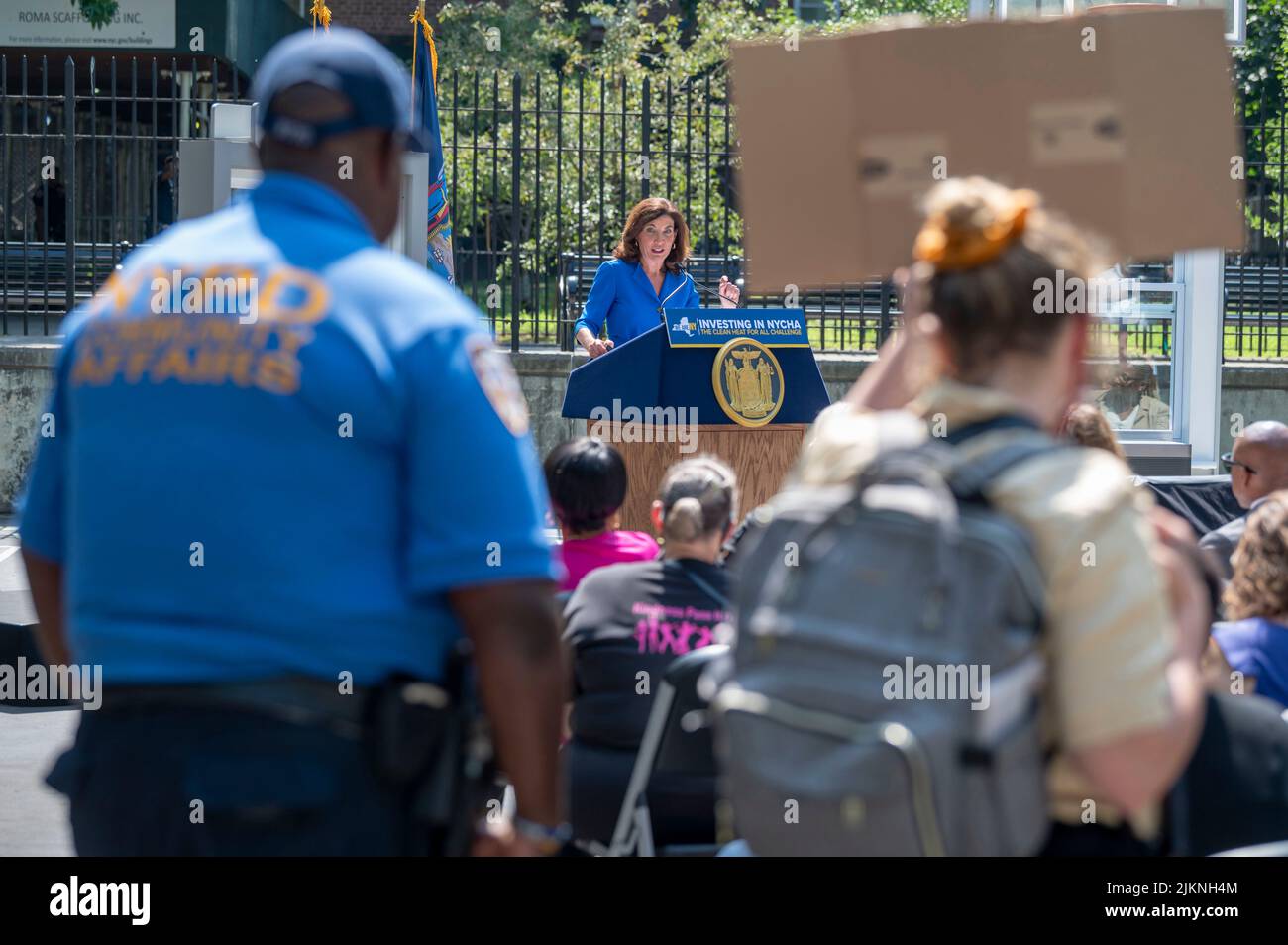 Une femme tient paisiblement un panneau disant « dump Driscoll