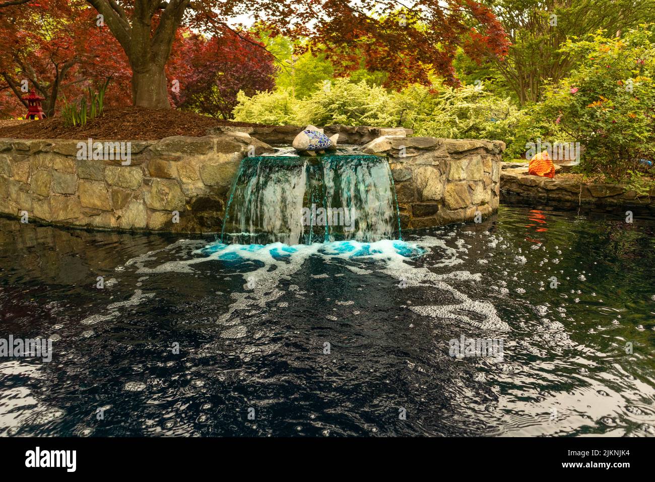 Une belle photo d'une eau tombant d'un mur rocheux et faisant de la rivière avec des arbres en arrière-plan Banque D'Images