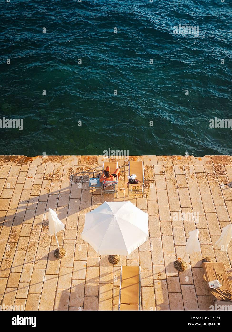 Vue panoramique sur un homme qui se détend et qui se bronzer sur la terrasse en bord de mer Banque D'Images