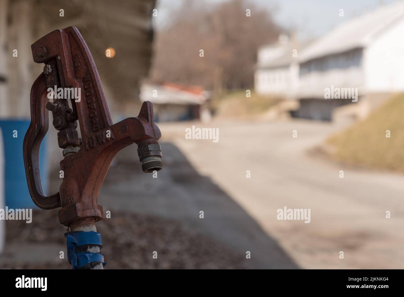 Un cliché sélectif d'un robinet d'eau dans un champ de courses abandonné Banque D'Images