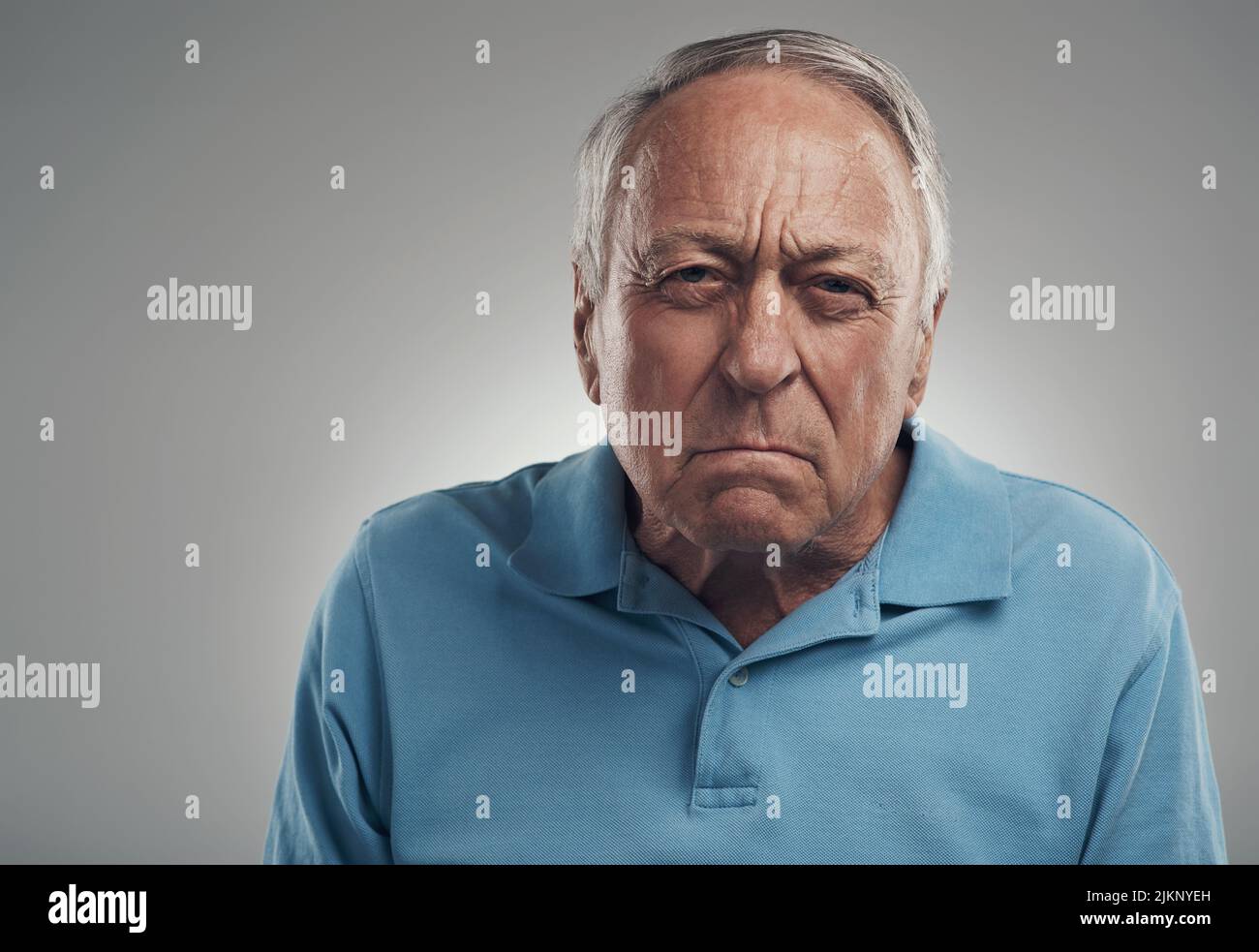 Vous me faites tellement fâché. Un vieil homme regardant avec colère la caméra dans un studio sur fond gris. Banque D'Images