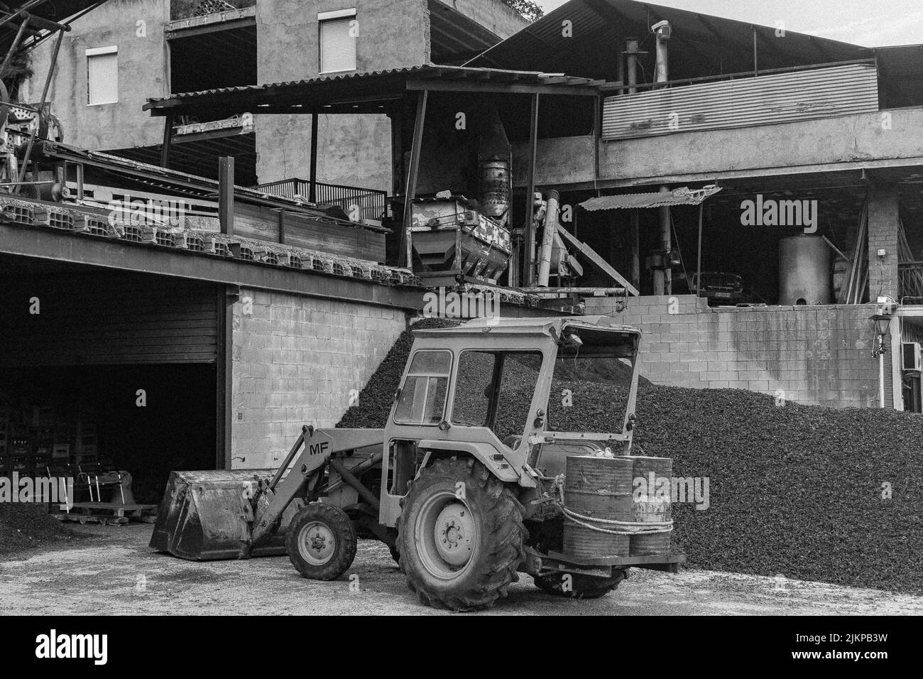 Vieux tracteur jaune avec pelle dans l'ancienne usine. Modèle Massey Ferguson Banque D'Images