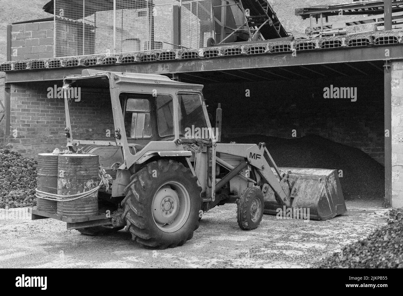 Vieux tracteur jaune avec pelle dans l'ancienne usine. Modèle Massey Ferguson Banque D'Images