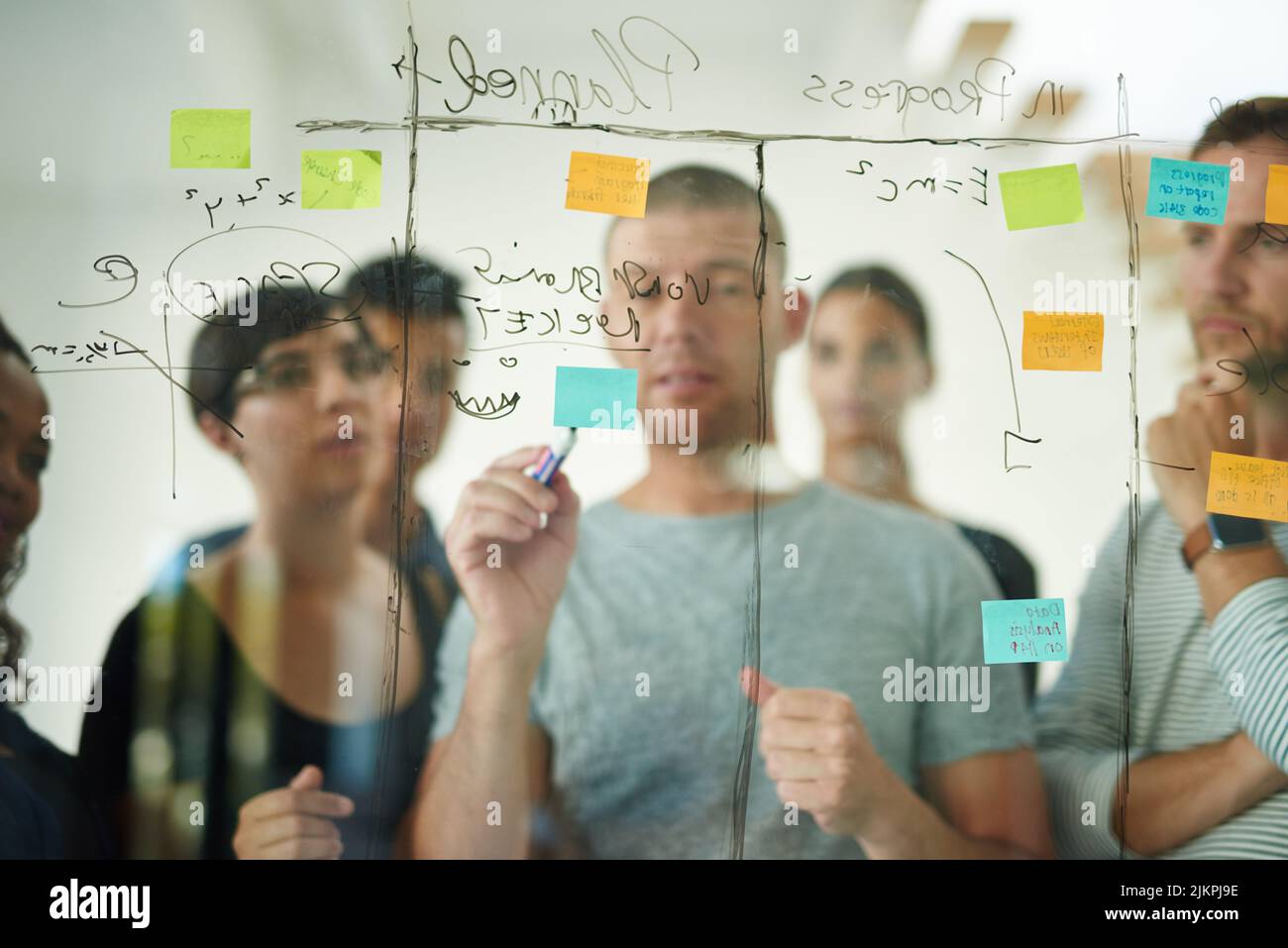 Groupe de personnes créatives d'affaires brainstorming des idées sur un tableau de verre. Formation des collègues, travail d'équipe dans un atelier ou un séminaire pour apprendre l'innovation Banque D'Images