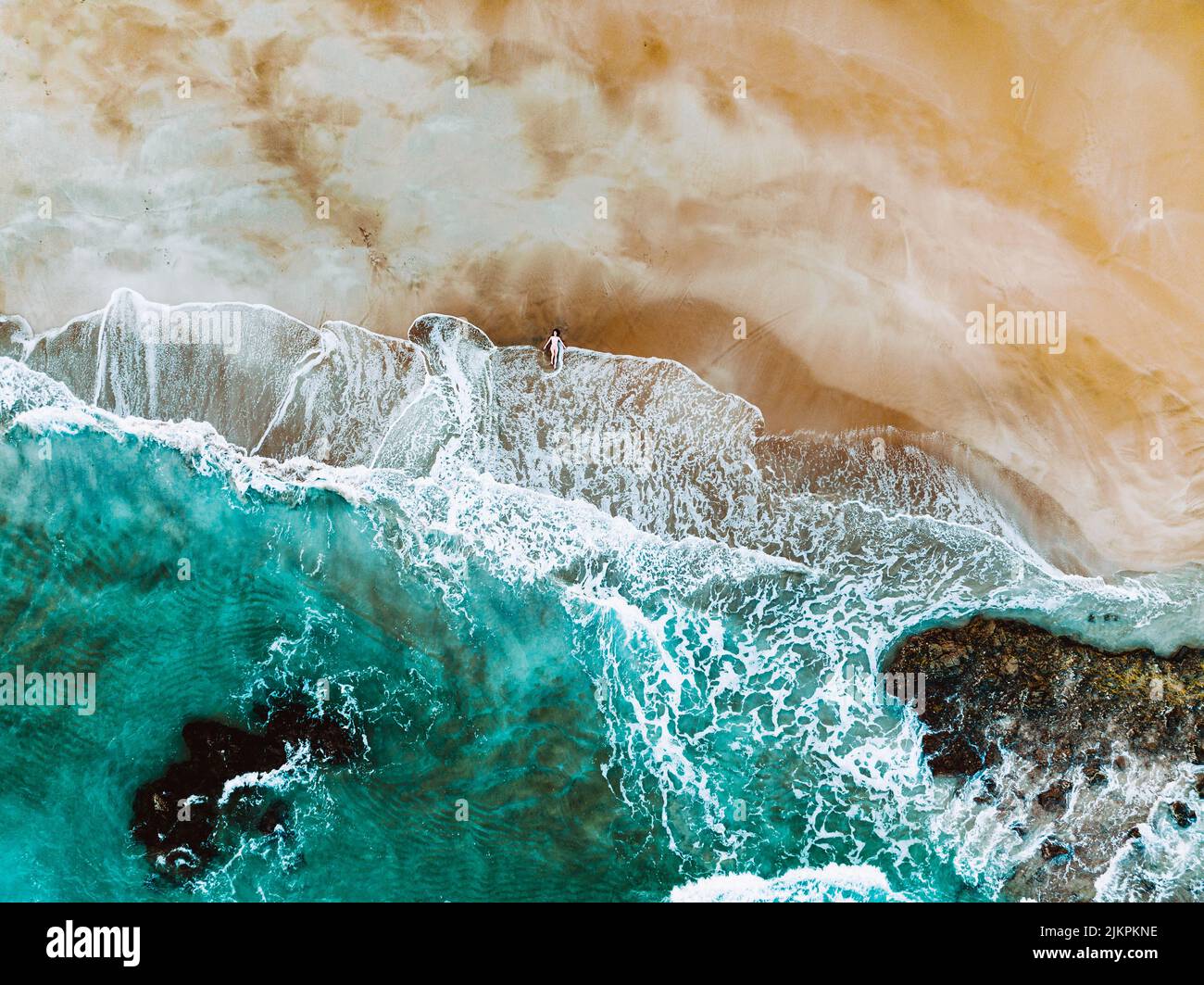 Une vue aérienne des vagues qui éclabousse sur une rive sablonneuse Banque D'Images