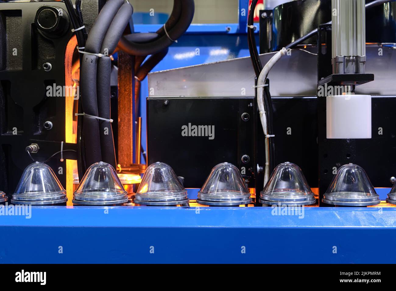 Sécheur de conteneur en gros plan machine fonctionnant avec du plastique transparent via une chaîne de montage à travers un processus de chauffage pour sortie sur le produit Banque D'Images